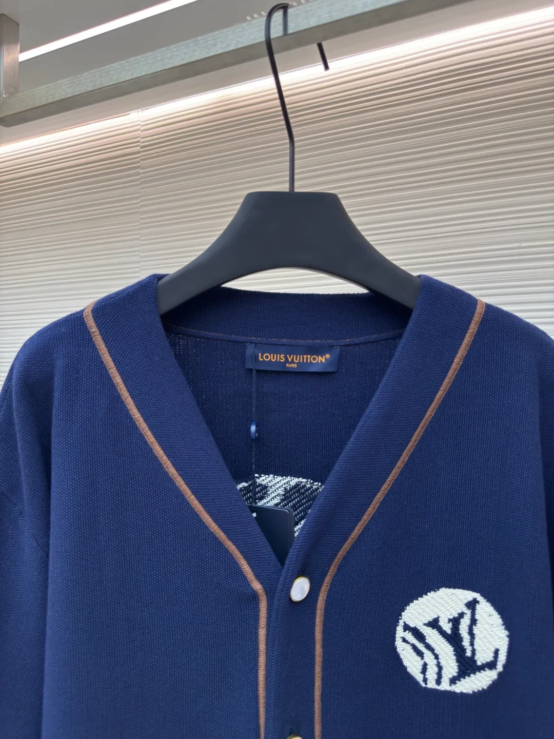 LOUIS VUITTON baseball knitted short-sleeved shirt ●Authentic product: Purchased and developed for 15999 ●Item number: 1680120-B65 ●Fabric: Customized cotton fabric ●Technology: Knitted production ●Version: loose fit ●Weight: about 530 grams ●Size: S-M-L-XL ●Description: Purchased YB pattern making, using imported custom-made cotton fabrics. The knitted texture is fine, uniform and high-end, and has good skin-friendliness; the white logo embroidery stitches before and after the embroidery are delicate; the embroidery threads are closely arranged, and the edges are smooth and regular. The three-dimensional effect is outstanding and increases brand recognition; the buttons are made of pearl material with a warm luster. The button hole position is manually positioned and opens and closes smoothly; the 1854 label in the lower left corner is neatly cut and has fine stitching; the label and the main body of the clothing are sewn firmly and evenly, which not only highlights the brand's historical heritage, but also becomes the finishing touch in the overall design! The overall routing is straight and delicate, the fabric is comfortable and soft, and the color is consistent without color difference. It can be matched with the same style to create a fashionable look and control various occasions. Customized accessories, complete three labels, the same style for men and women!